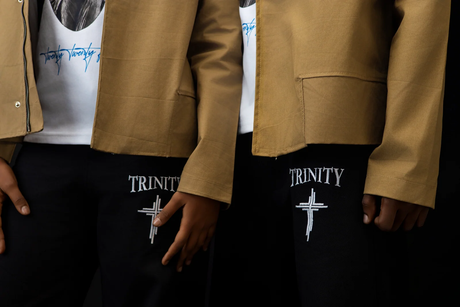 Both models side by side, the same Trinity embroidery on the left side of each pair of pants