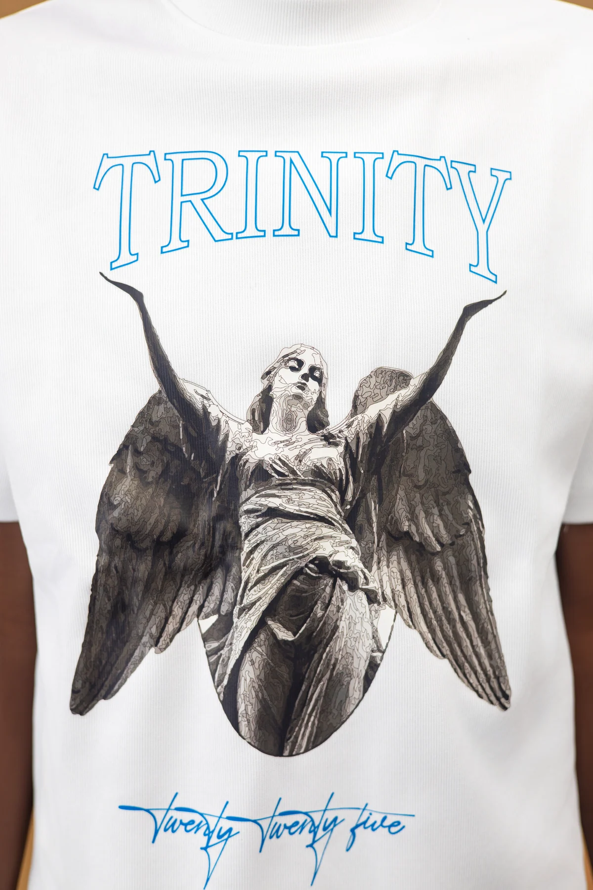 Close view of the sculptural angel artwork printed on the white shirt