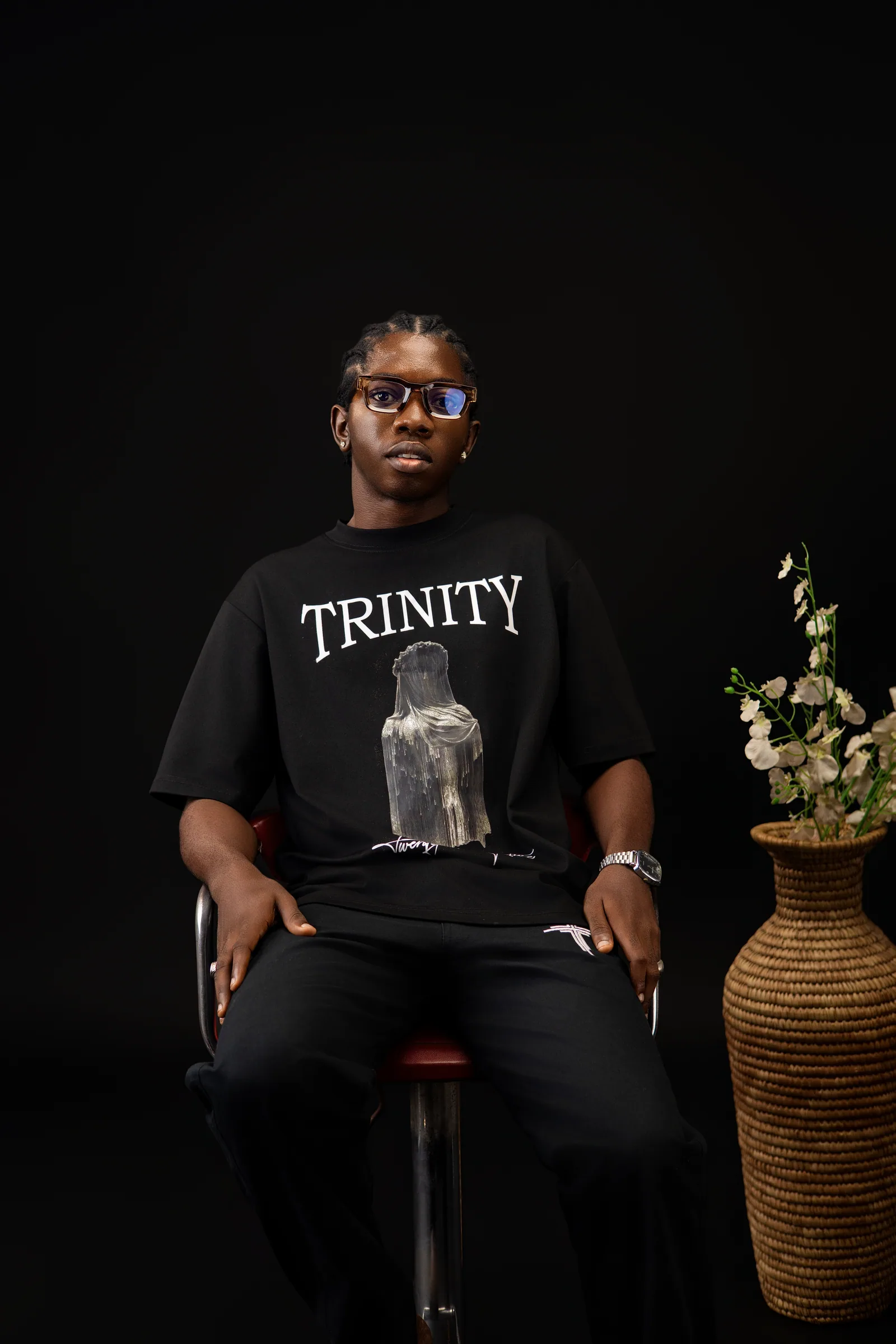 The founder of Trinity, seated, wearing the black shirt and pants