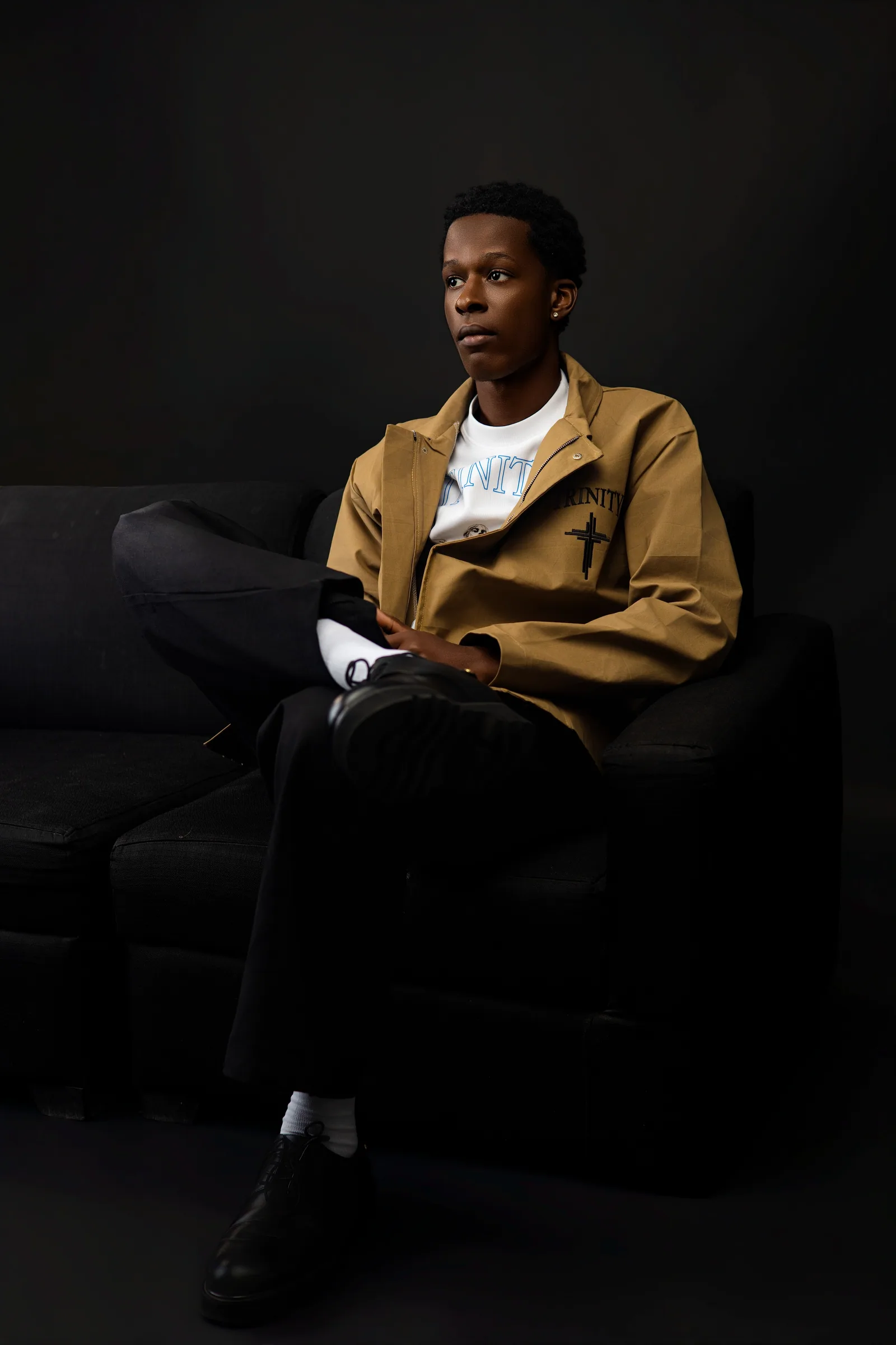 Male model seated wearing the tan jacket